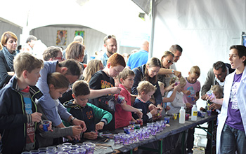 Kids at a table making slime in a cup